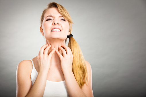 Health problem, skin diseases. Young woman scratching her itchy neck with allergy rash