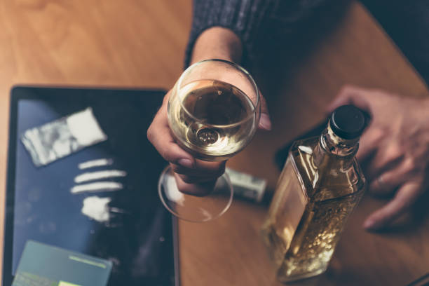 top view of man drink alcohol and using drugs, selective focus on glass with whiskey - alcohol drug abuse alcoholism pill imagens e fotografias de stock