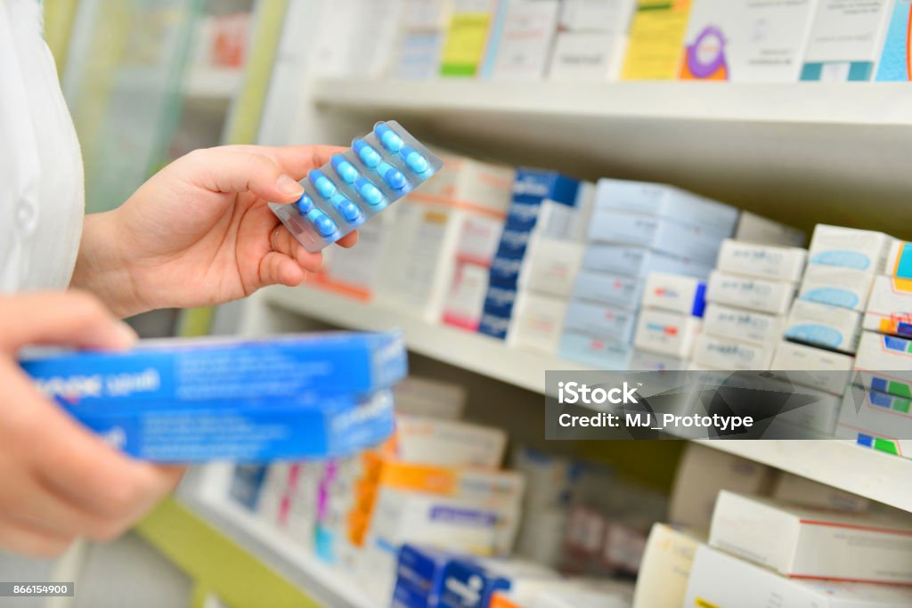 Pharmacist holding medicine box and capsule pack Pharmacist holding medicine box and capsule pack in pharmacy drugstore. Pharmacy Stock Photo