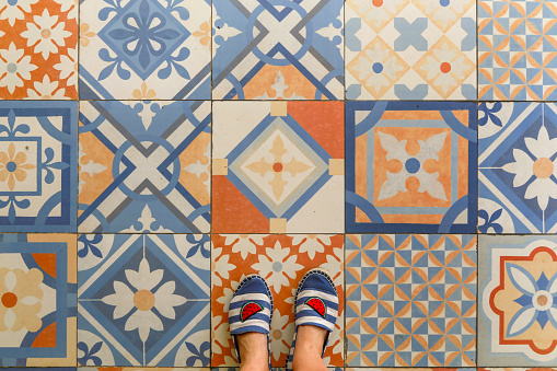 Upper view of summer shoes and decorative retro porcelain tile
