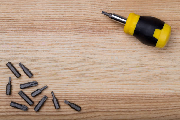 Aerial view screwdriver with set of bits on wooden table stock photo