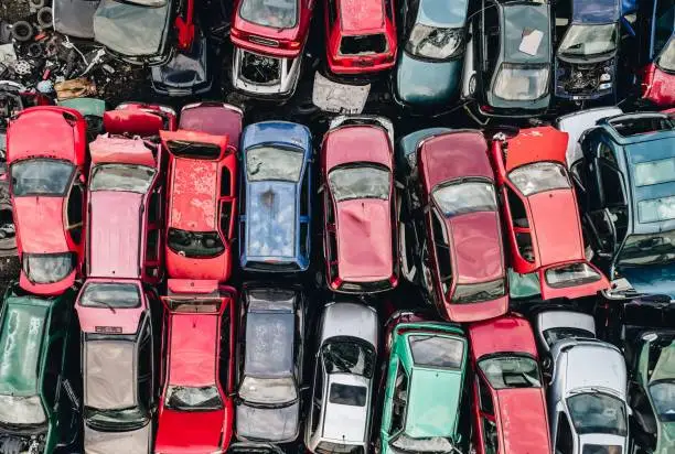 Photo of Old rusty corroded cars in car scrapyard.