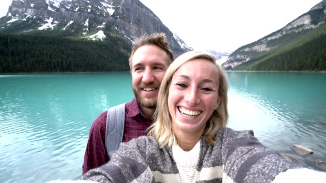 Young couple taking selfie portrait at Lake Louise