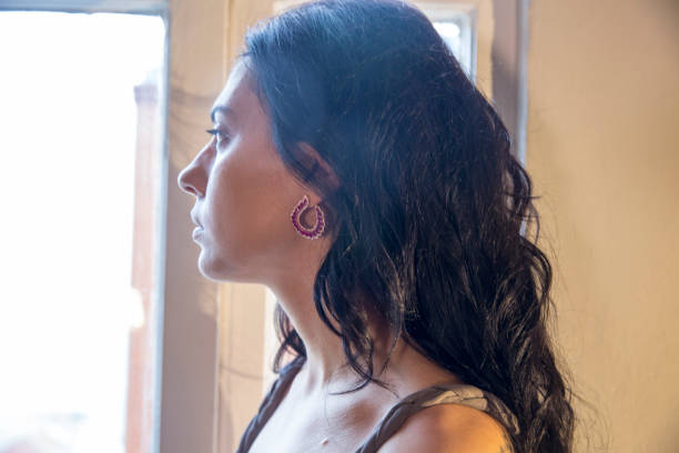 istock Young beautiful woman is looking through the window 866163116