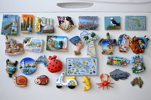 Many different souvenir magnets on the fridge