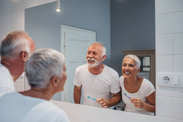 Brighter teeth for a brighter future A senior couple comparing their white teeth after brushing up in the morning. old man pajamas photos stock pictures, royalty-free photos & images
