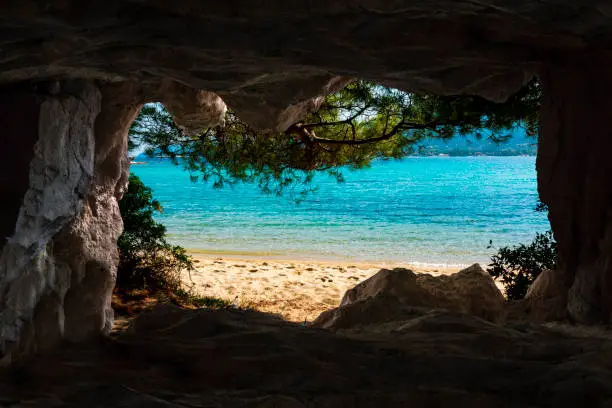 View of the beach from the cave inside in Vourvourou, Halkidiki, Greece.