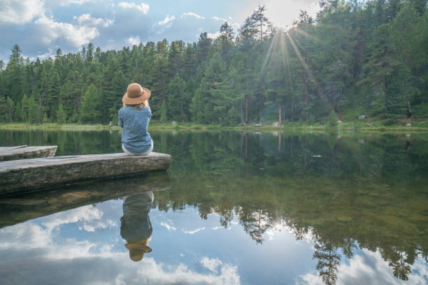 Young woman contemplating nature by the lake