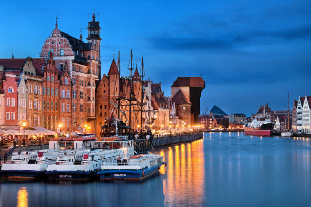 Gdansk old town and Motlawa river at night Night picture of Gdansk (Poland) with the old Crane and ships on Motlawa river gdansk city stock pictures, royalty-free photos & images