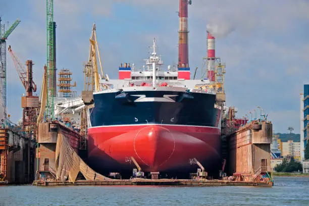 Picture of a large oil tanker receiving maintenance in a shipyard floating dry dock