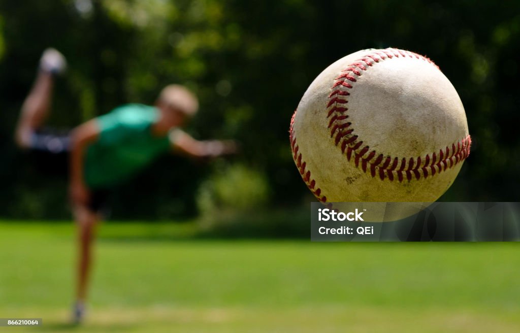 America's Pastime A baseball hurdles toward the plate as the pitcher completes his follow-through. Baseball - Ball Stock Photo