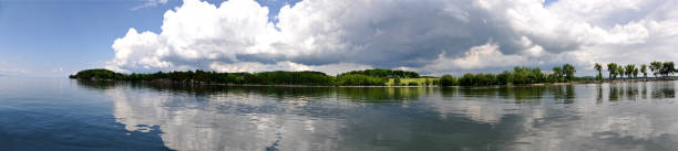 istock Panoramic view of trees and lake and clouds 866211052