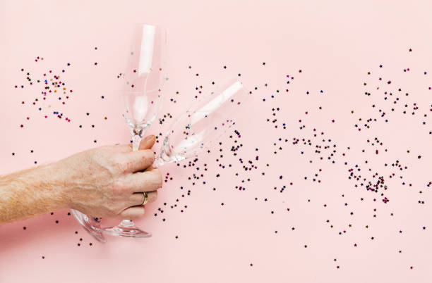 istock A man's hand holding two empty glasses for champagne. festive background and empty space for writing text 866211198