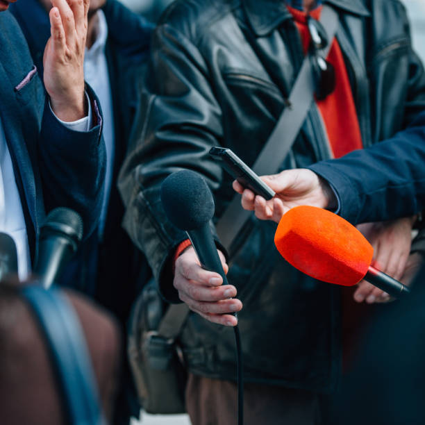 istock Journalists gathering around politician, looking for interview 866214484