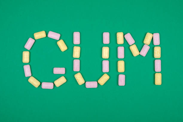 Word GUM written with chewing gum on green background
