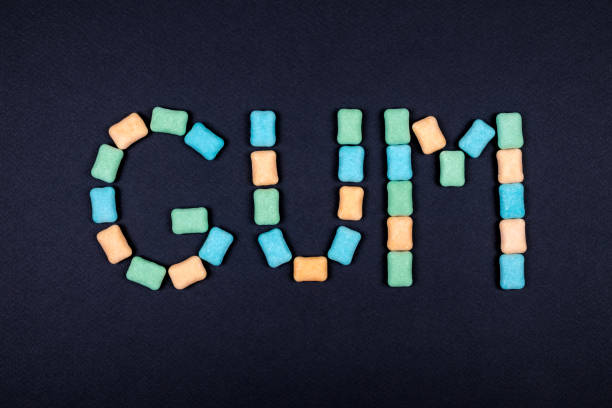 istock Word GUM written with chewing gum on black background 866215142
