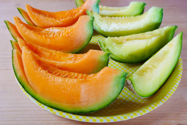 Close up fresh sliced melon with plate on wooden background at melon farm in Furano, Hokkaido, Japan. Close up fresh sliced melon with plate on wooden background at melon farm in Furano, Hokkaido, Japan. Juicy summer sweet fruit. furano basin stock pictures, royalty-free photos & images