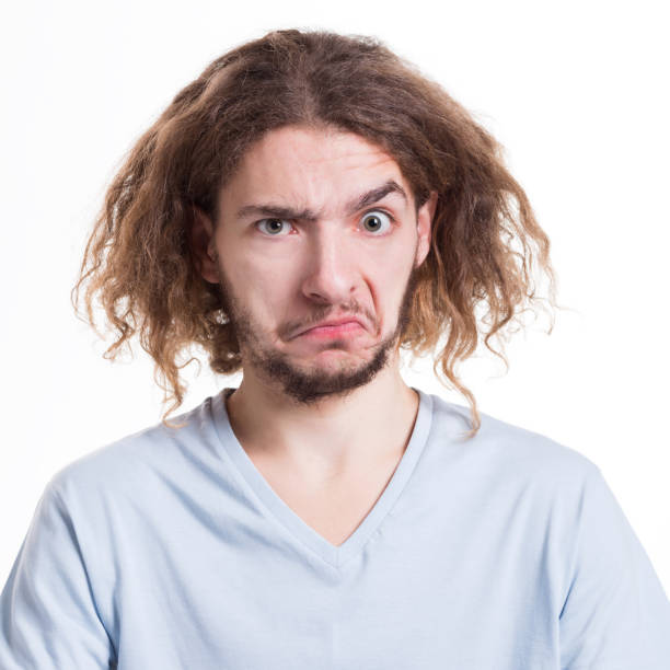 Negative human emotion, man feels unpleasant surprised Negative human emotion. Man expressing unpleasant feelings on face, grimacing on white studio background, cutout ugly face stock pictures, royalty-free photos & images