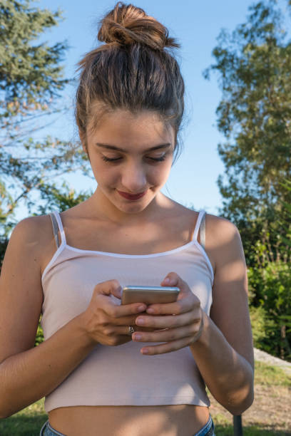 istock Young Blond Girl Texting on a Mobile Phone 866228094