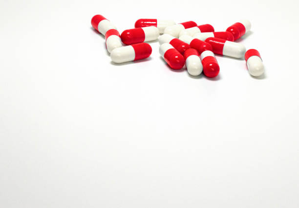 istock Background of assorted pharmaceutical capsules in white-red. 866232798