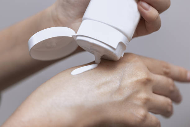 istock Young woman is using white lotion on her hand, beauty concept 866240554