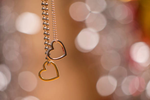 istock two heart pendants with necklace isolated on soft glowing background 866248078