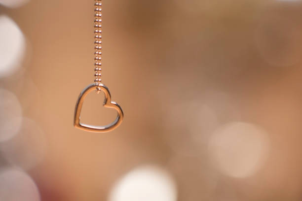 wisiorek serca z naszyjnikiem wyizolowanym na miękkim świecącym tle - necklace jewelry heart shape gold zdjęcia i obrazy z banku zdjęć