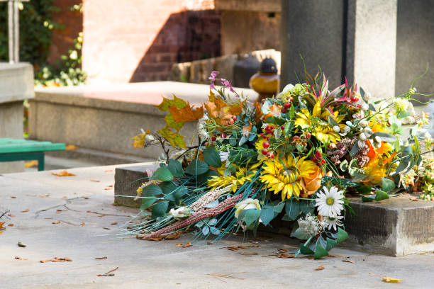 Artificial flowers bouquet on the grave. Cemetery decorations