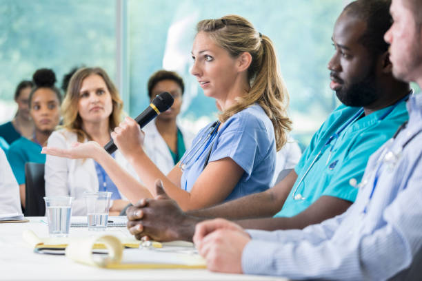 istock Serious nurse answers question during panel discussion at a seminar 866255382