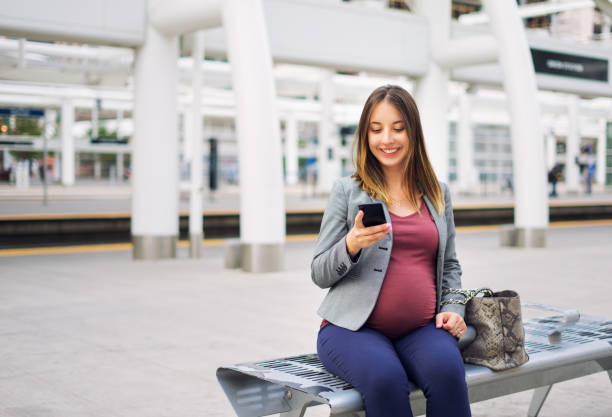 istock Pregnant woman on the phone while waiting for a train 866256852
