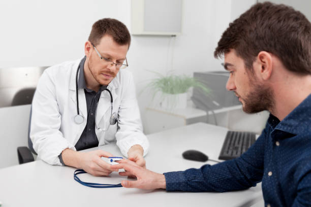 Un médecin consulte un oxymètre de pouls - Photo