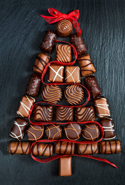 Chocolate pralines Christmas tree on stone black Chocolate pralines Christmas tree on stone black table chocolate pieces stock pictures, royalty-free photos & images