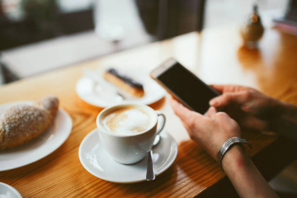 istock Close-up of woman's hands typing on the smartphone while having a coffee 866276646