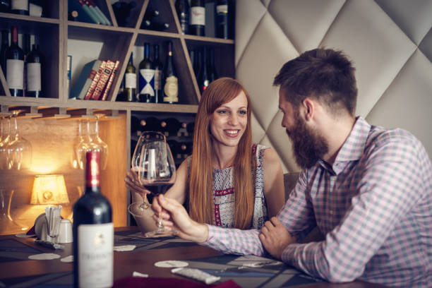istock Beautiful couple ordering dinner and drinking French red wine 866286012