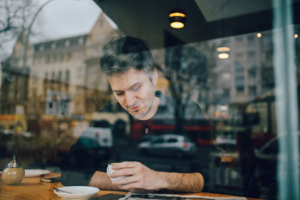 istock Young man relaxing in a cafe in Berlin, reading the newspapers 866290584