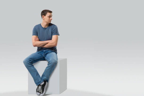 istock Man sitting on a cube and looking away - isolated 866290782