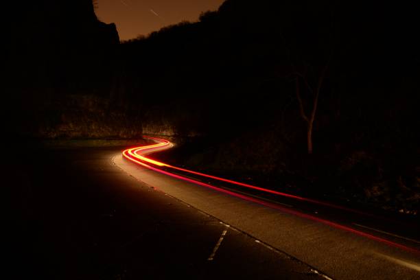 Cheddar Gorge at night long exposure of a car driving through Cheddar Gorge at night cheddar gorge stock pictures, royalty-free photos & images