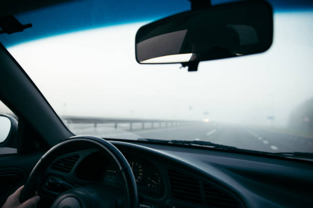 istock man driving car in fog 866305836