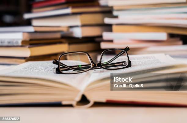 Gafas De Lectura En Un Libro Foto de stock y más banco de imágenes de Investigación - Investigación, Educación, Dos objetos