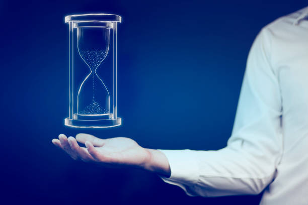 istock Man's hand holding hourglass sand 866343710