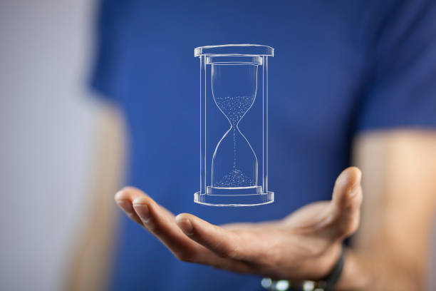 istock Man's hand holding hourglass sand 866343754
