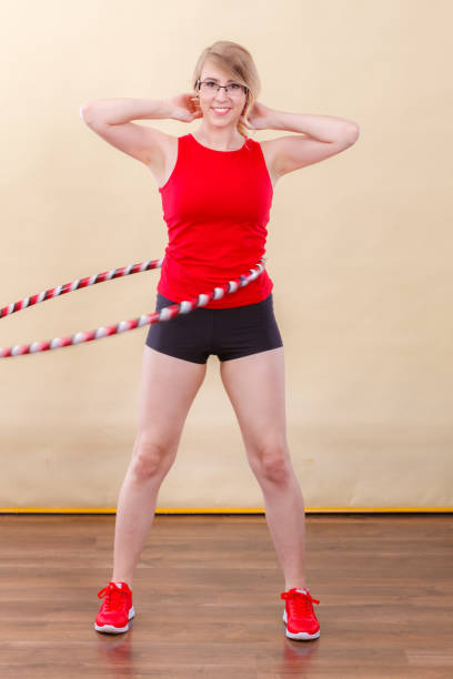 istock Fit woman with hula hoop doing exercise 866346876