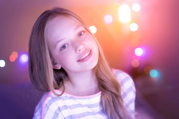 Emotting happiness. Cheerful blond blue-eyed girl smiling and looking straight into the cam and her eyes shining