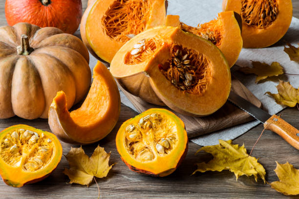 istock Sliced pumpkin with seeds on a wooden background. Close-up 866351026