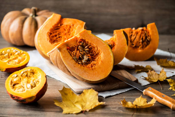 istock Sliced pumpkin with seeds on a wooden background. Close-up 866351040
