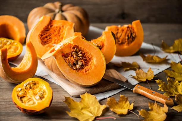 istock Sliced pumpkin with seeds on a wooden background. Close-up 866351042