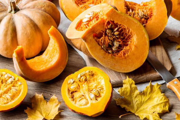 istock Sliced pumpkin with seeds on a wooden background. Close-up 866351094
