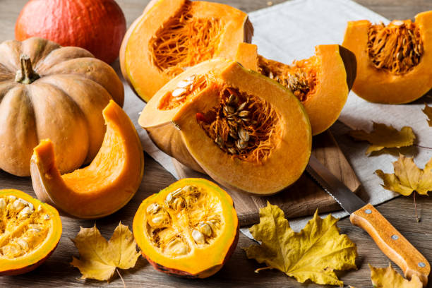 istock Sliced pumpkin with seeds on a wooden background. Close-up 866351380