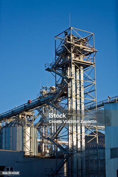 Tower Of Modern Metal Grain Elevator With Silos On Blue Sky Background Stock Photo - Download Image Now