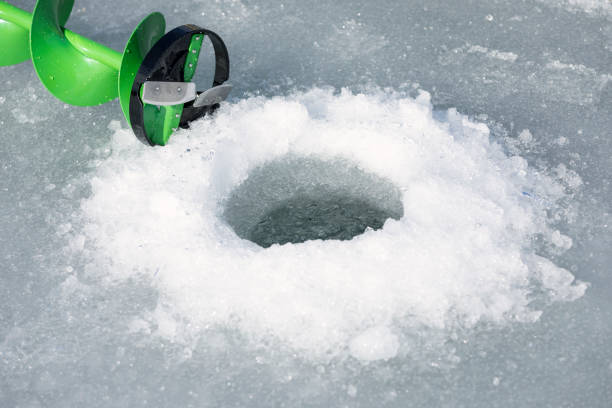 istock Ice Fishing Hole with Ice Auger 866354778
